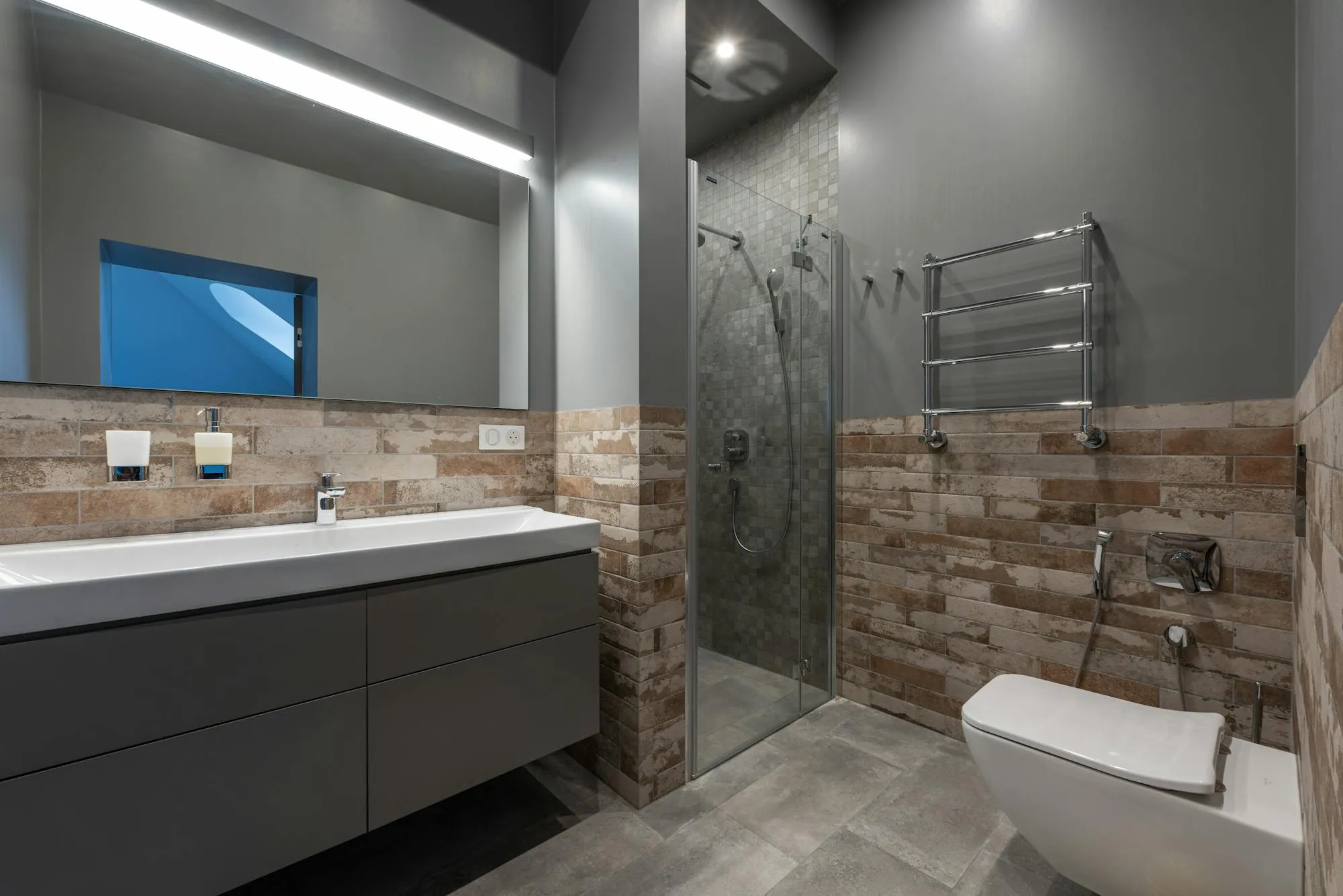 Modern bathroom with walk-in shower, vanity unit, and chrome heated towel rail.